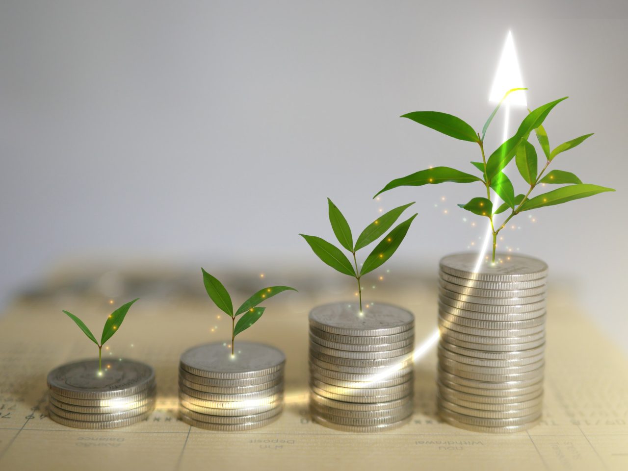 Stacks of coins, money, with plants sprout on top. Investment saving progress.